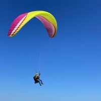 person in black jacket and black pants riding yellow and red parachute